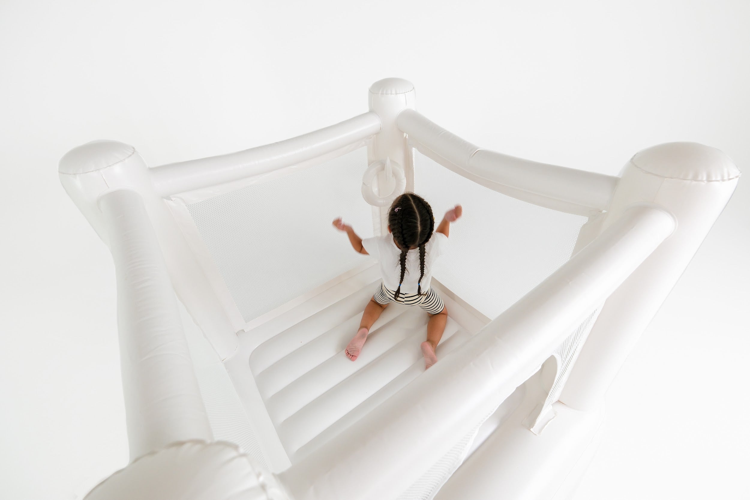 Child playing in indoor jumping castle with built‑in pump